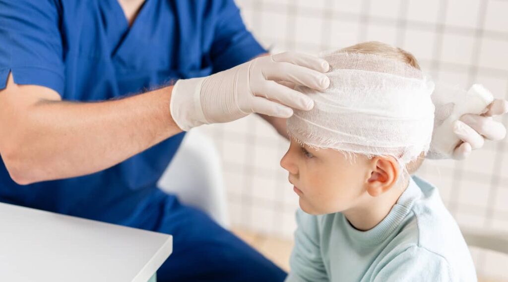 Doctor bandaging a child's head after a transport accident | Henry Carus + Associates