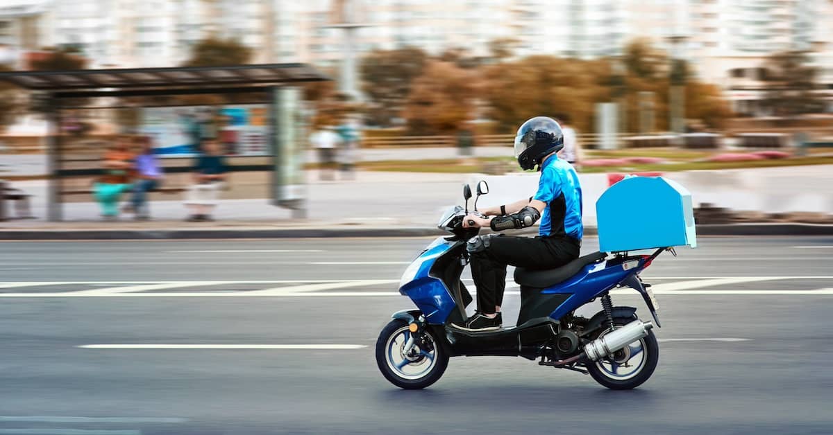 Food delivery rider on a motor scooter in Australia | Henry Carus + Associates