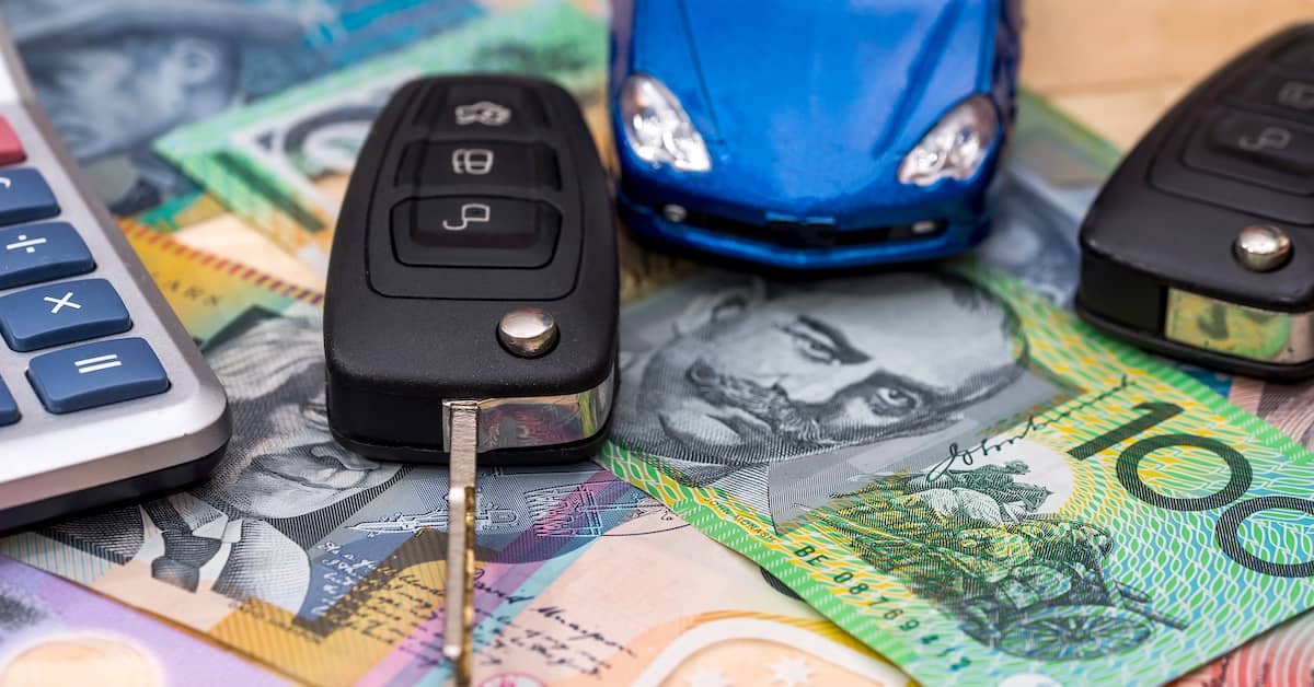 Car keys, calculator and toy car resting on Australian money | Henry Carus + Associates