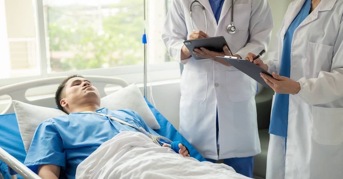 Doctors reviewing hospital patient's chart | Henry Carus + Associates