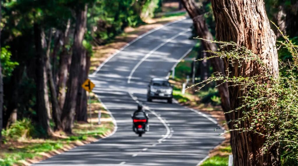 Motorbike travelling on a road outside Melbourne with another vehicle approaching | Henry Carus + Associates